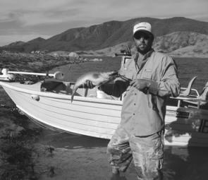 The author with an average cod from Blowering, caught off the rocky point in the background.